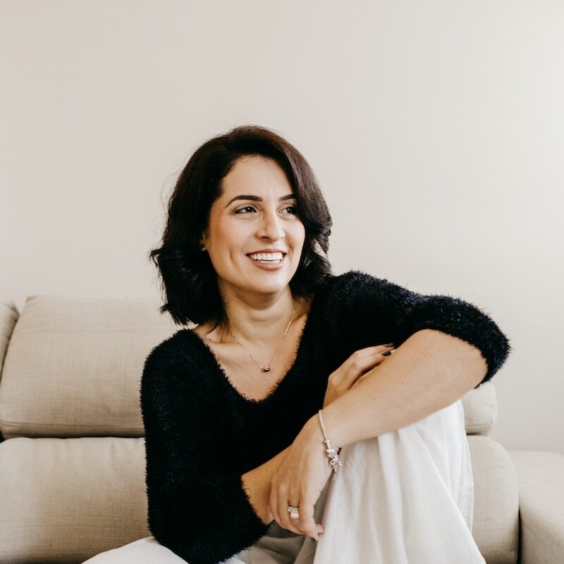 woman in black long sleeve shirt sitting on white couch